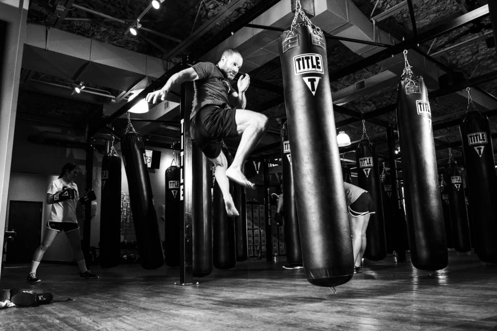 homme dans une salle de boxe avec un sac de frappe